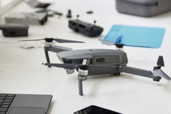 Close up of quadcopter drone on table in tech repair workshop, copy space